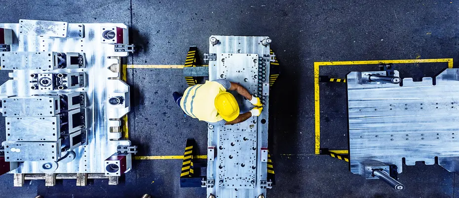  aerial image of worker in a hard hat surrounded by manufacturing equipment