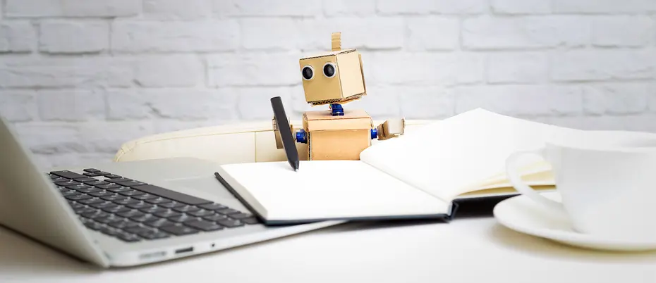 Robot writing and looking at laptop