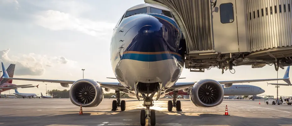 photo of a white and blue airplane waiting at its gate