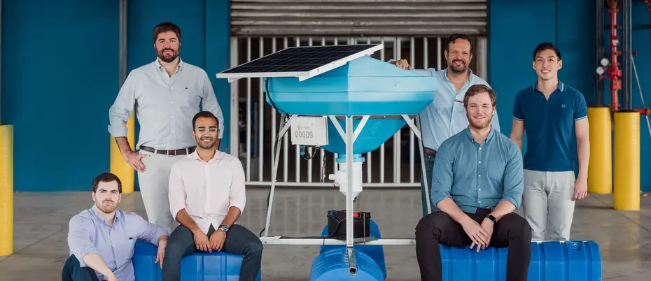 MIT Sloan students and bioFeeder co-founders posed around one of their shrimp-feeding systems.