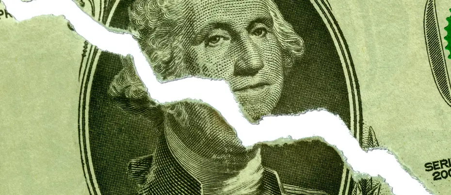 a dollar bill with a jagged diagnoal tear, meant to represent recession