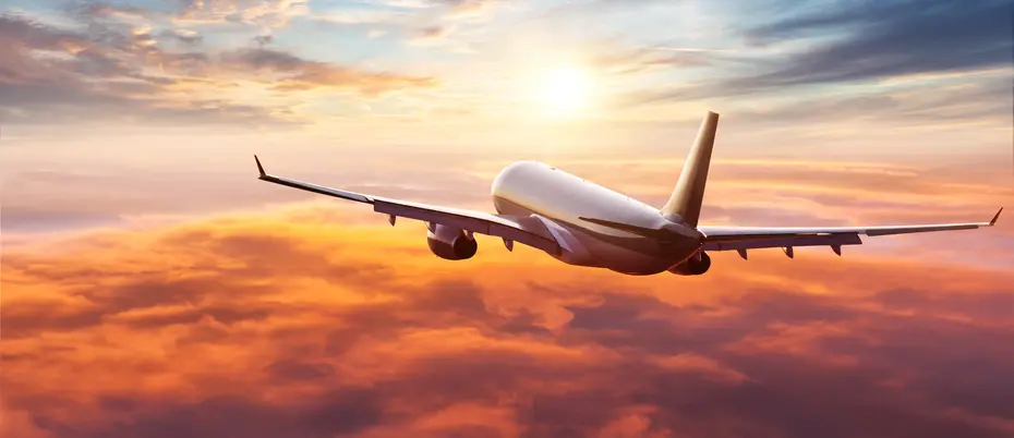 airplane flying into sunset