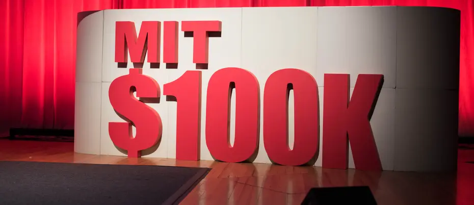 MIT $100K logo and backdrop on stage.