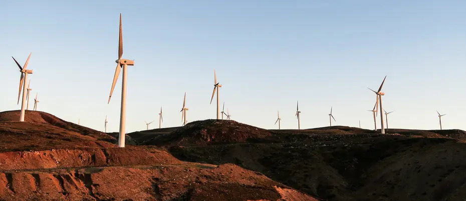 Photo of dozens of wind turbines on rocky landscape.
