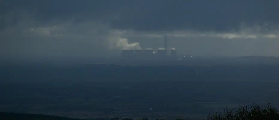 Coal pollution from a power plant shown in distance.