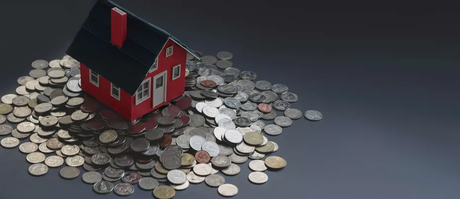 Toy house on pile of coins