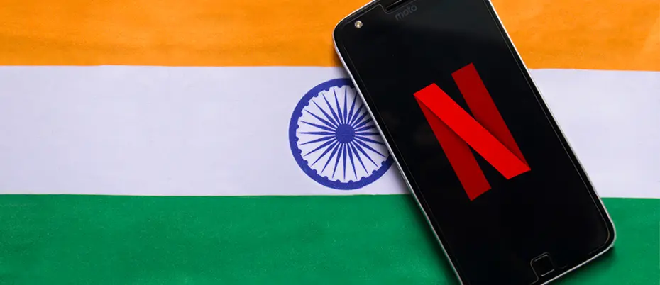 Cell phone with Netflix icon on top of an Indian flag