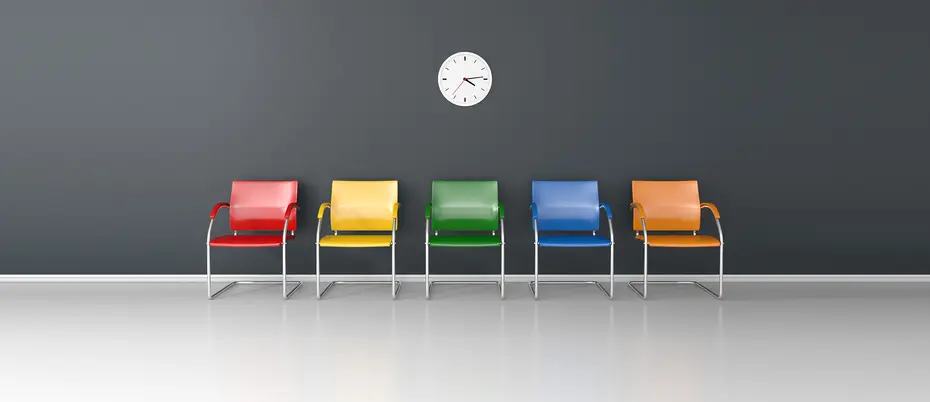 An illustration of five colorful chairs against a wall with a standard clock on the wall above them.