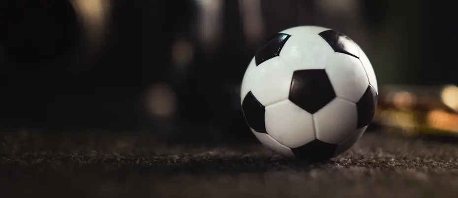 Black and white checkered soccer ball on field.