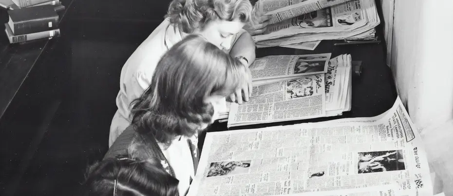 Vintage photo of women reading the newspaper.