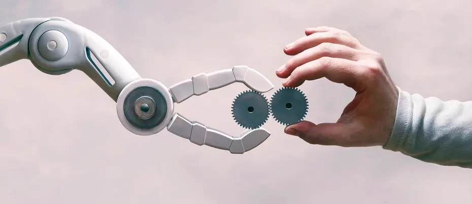 A robot hand and a human hand holding gears together