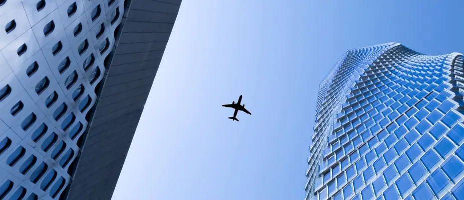 Airplane in flight above skyscrapers
