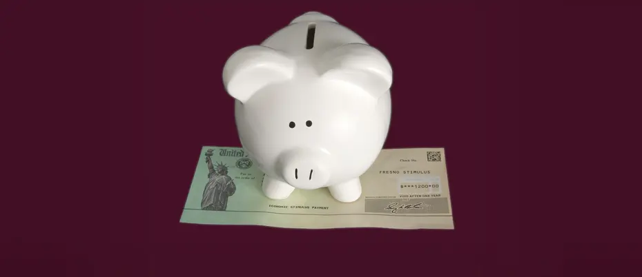 Piggy bank sitting on top of a US government check