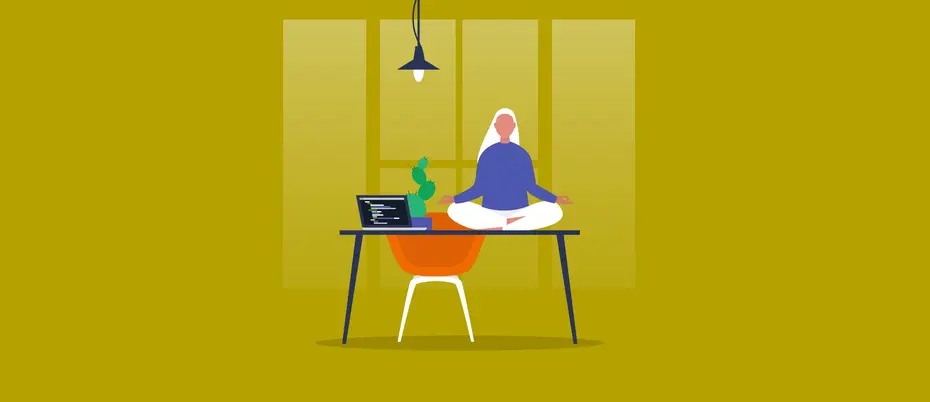An employee sits on top of a work desk meditating