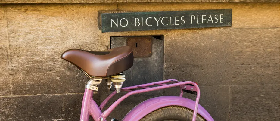 A bicycle resting on a "no bicycle please" sign 