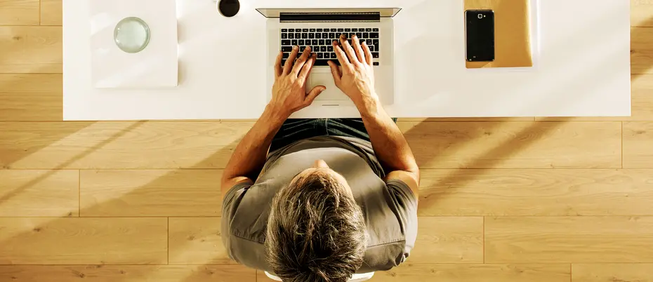 A person typing on a laptop at an office desk
