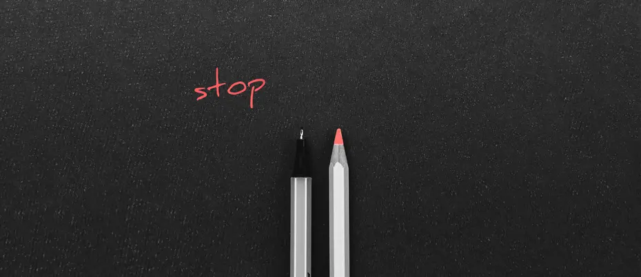 A pen and a colored pencil side by side with the word "stop" above