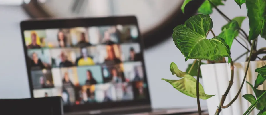 A team meeting via video conference appears on a laptop