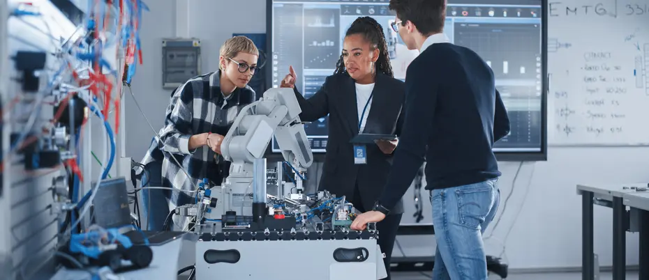 Female Teacher and Two Students Work With Prototype of Robotic Hand