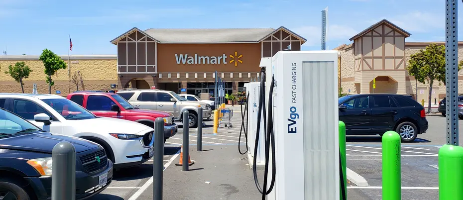 Several EVgo fast charging electric vehicle recharging stations in a Walmart parking lot.
