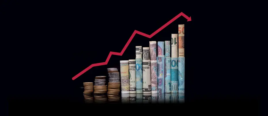 A red line graph over a stack of money in different currencies