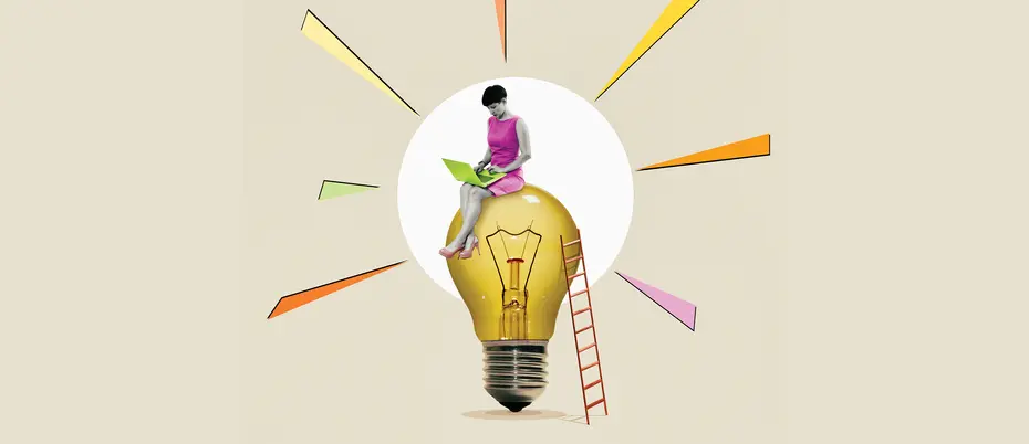 A person on a laptop sits on top of a lightbulb