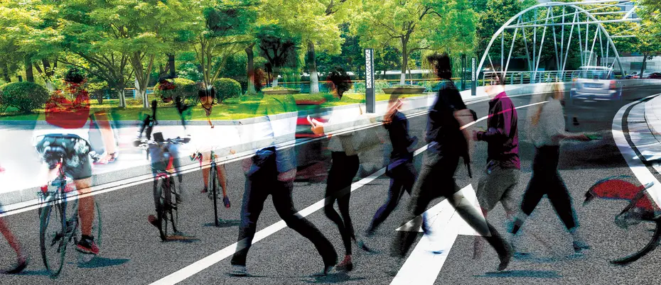 Pedestrians and cyclists on a street by a luscious park