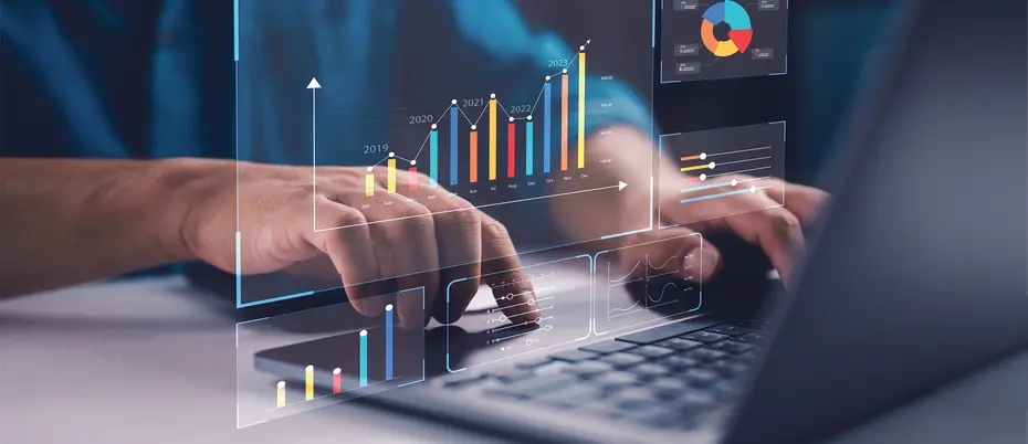 A person uses a laptop with a KPI dashboard appearing with various stats and analytics