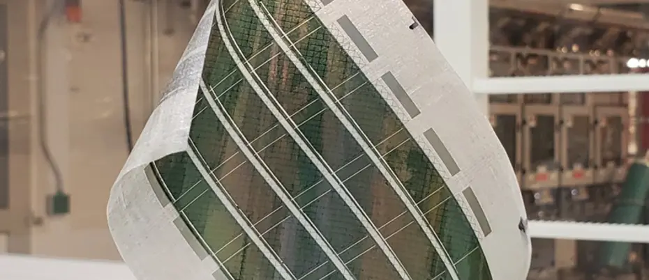 Image shows a gloved hand holding a flexible solar panel