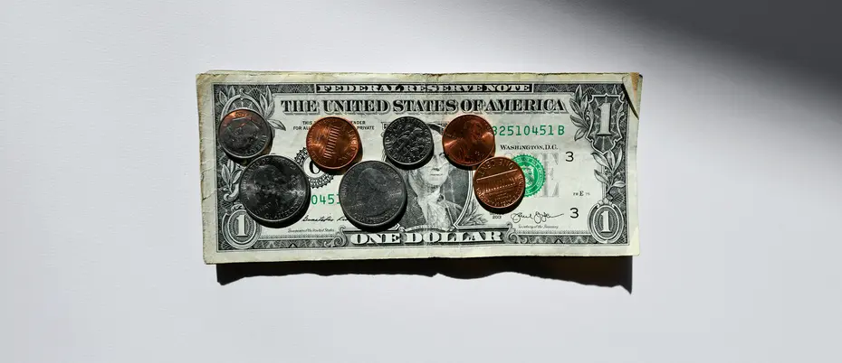Coins on top of a dollar bill