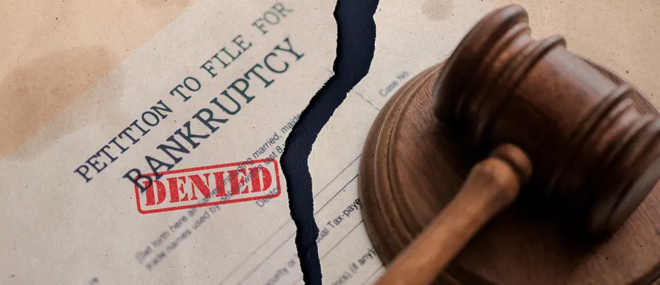 Petition to file for bankruptcy document torn in half with the stamp "denied" on it