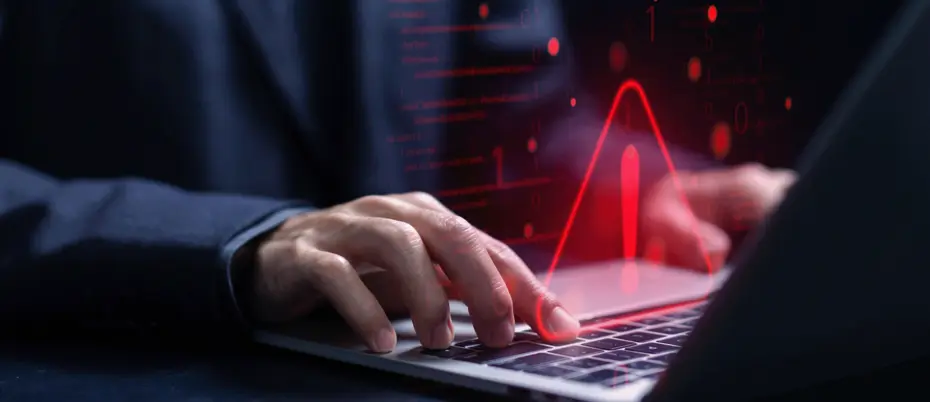 Hands on laptop with warning pop-up