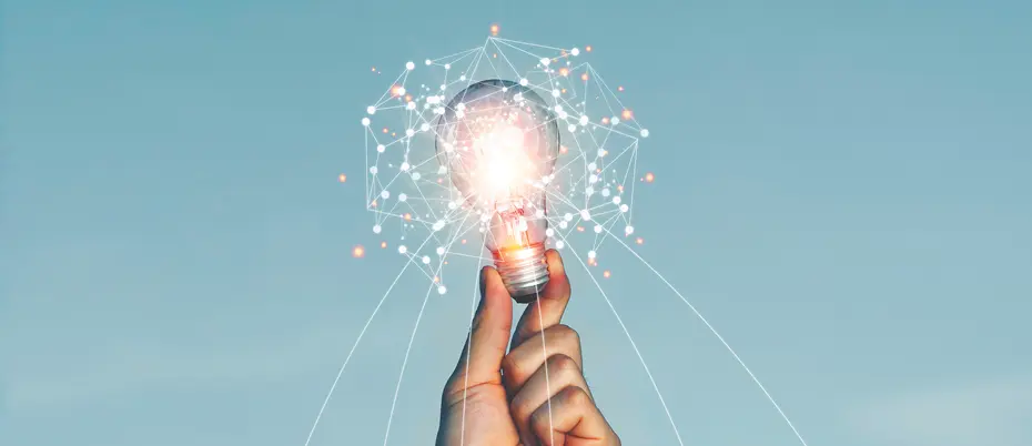 A person holds up a lightbulb covered in AI data imagery