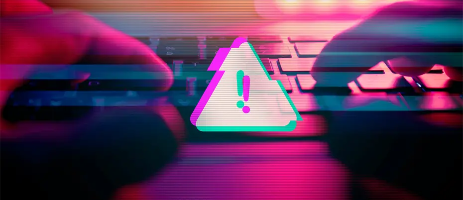 A person types on a keyboard with a malware virus alert