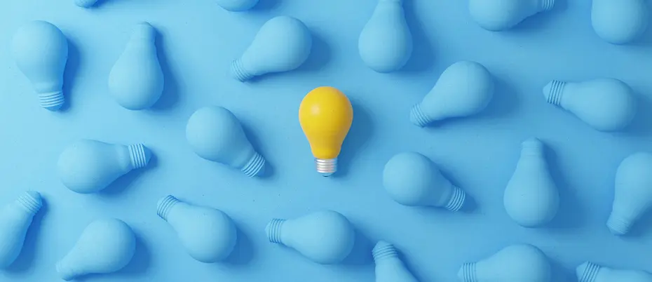 One yellow lightbulb amongst a plethora of blue lightbulbs