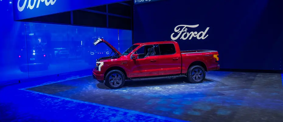 Red ford truck with open hood in a car show environment