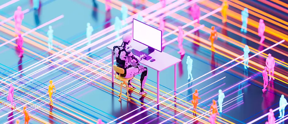 A robot works at an office desk with human workers in the background