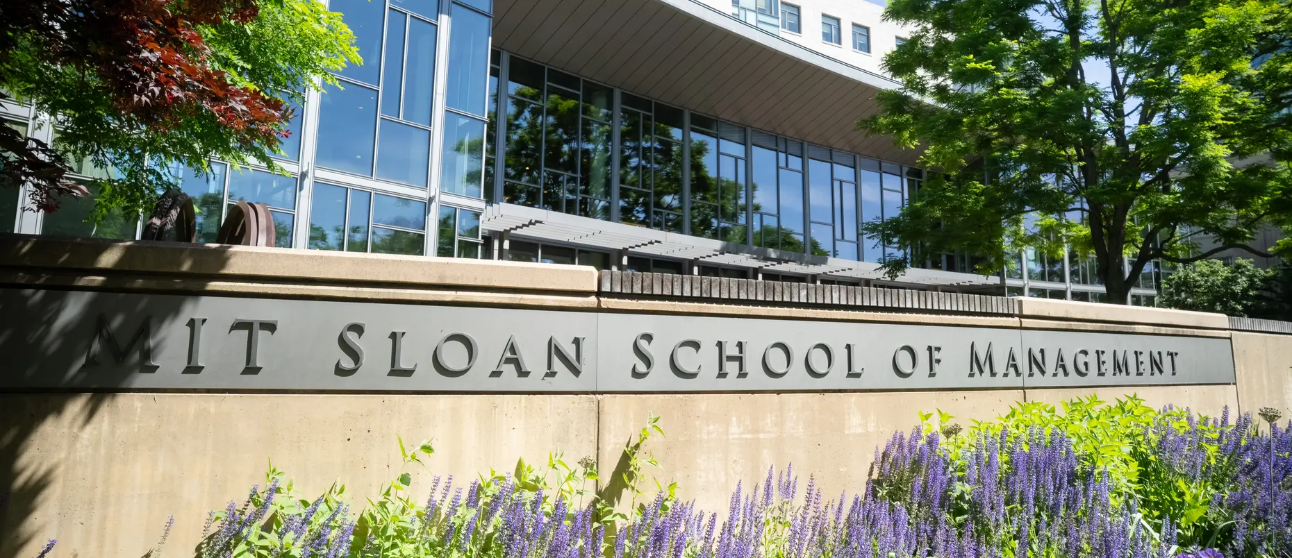 Exterior photo of MIT Sloan's main building E62 with plants