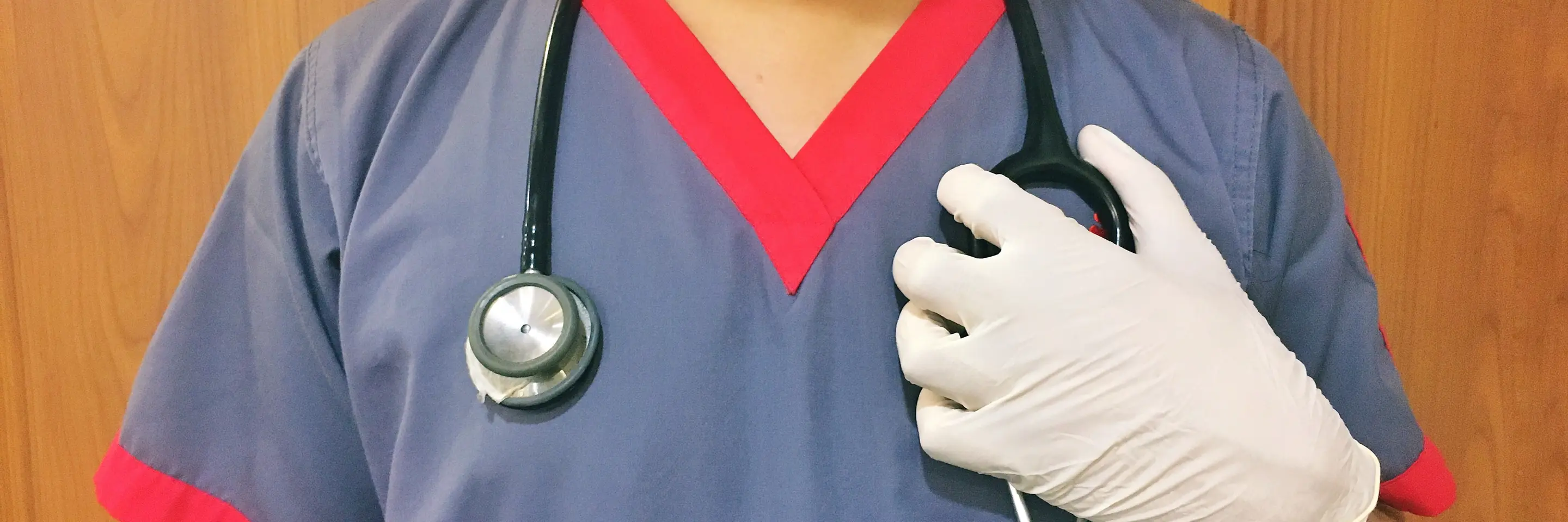 Nurse in face shield and mask with stethoscope draped over her shoulders