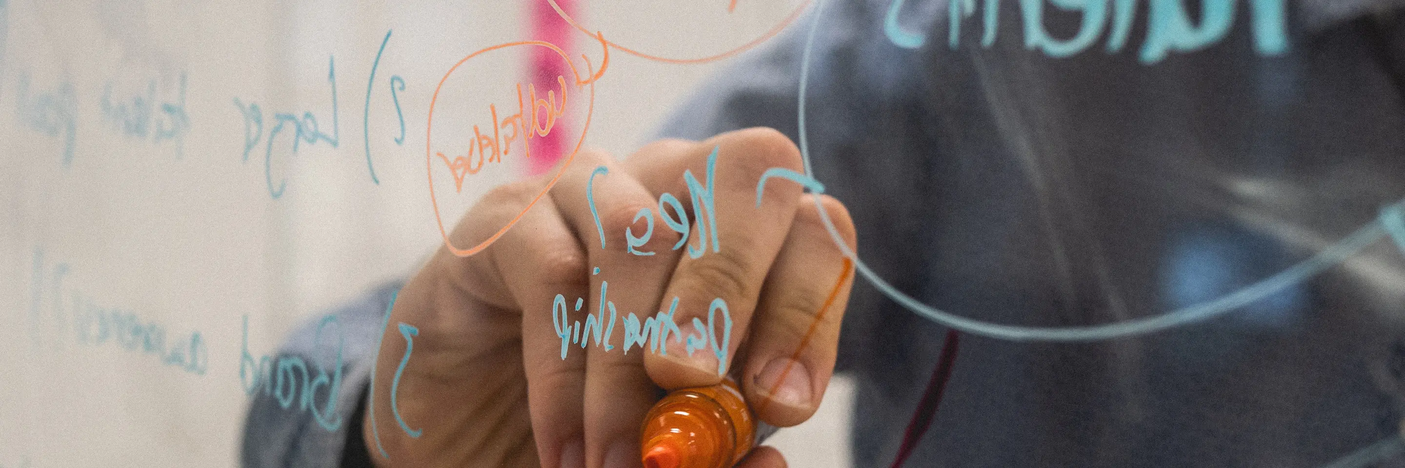 Person writing on glass wall 