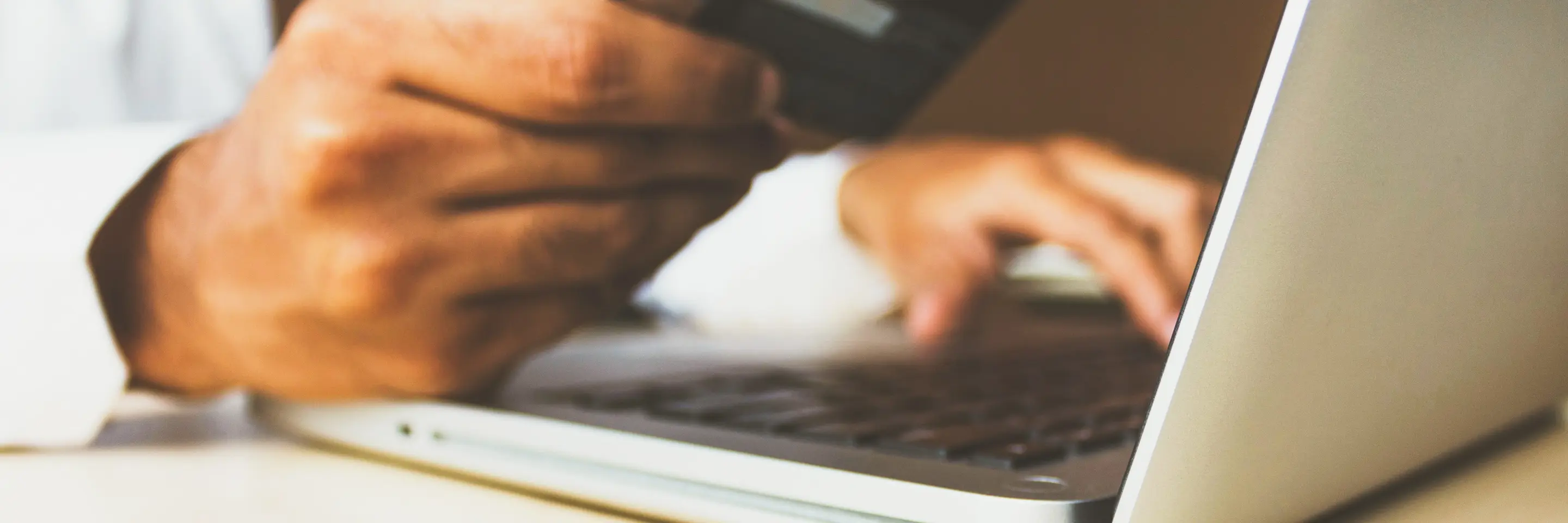 Man holding credit card over laptop