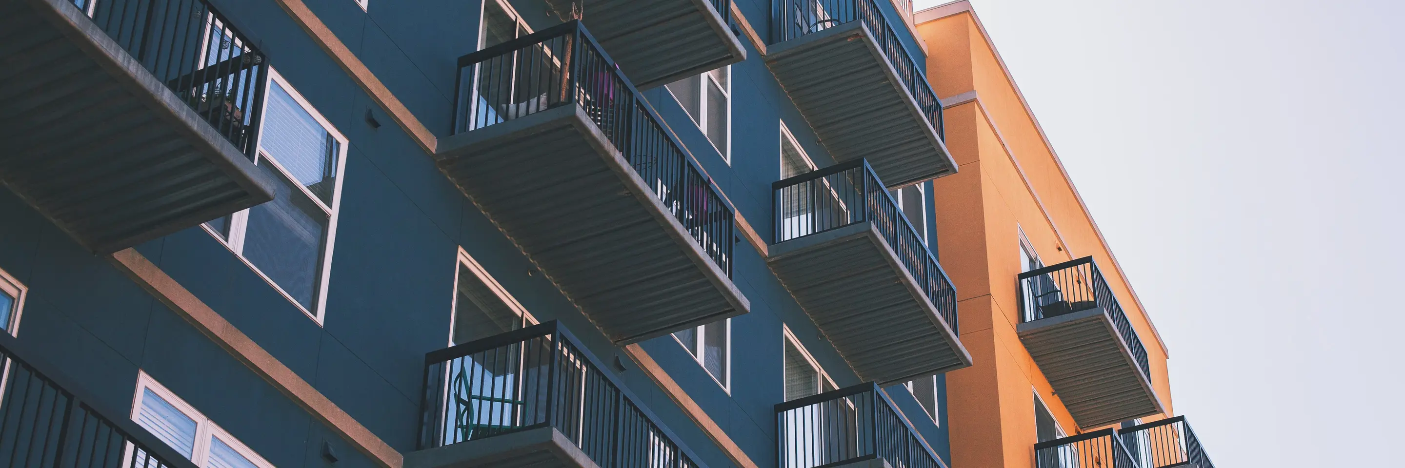 Dark green and orange apartment building with balconies