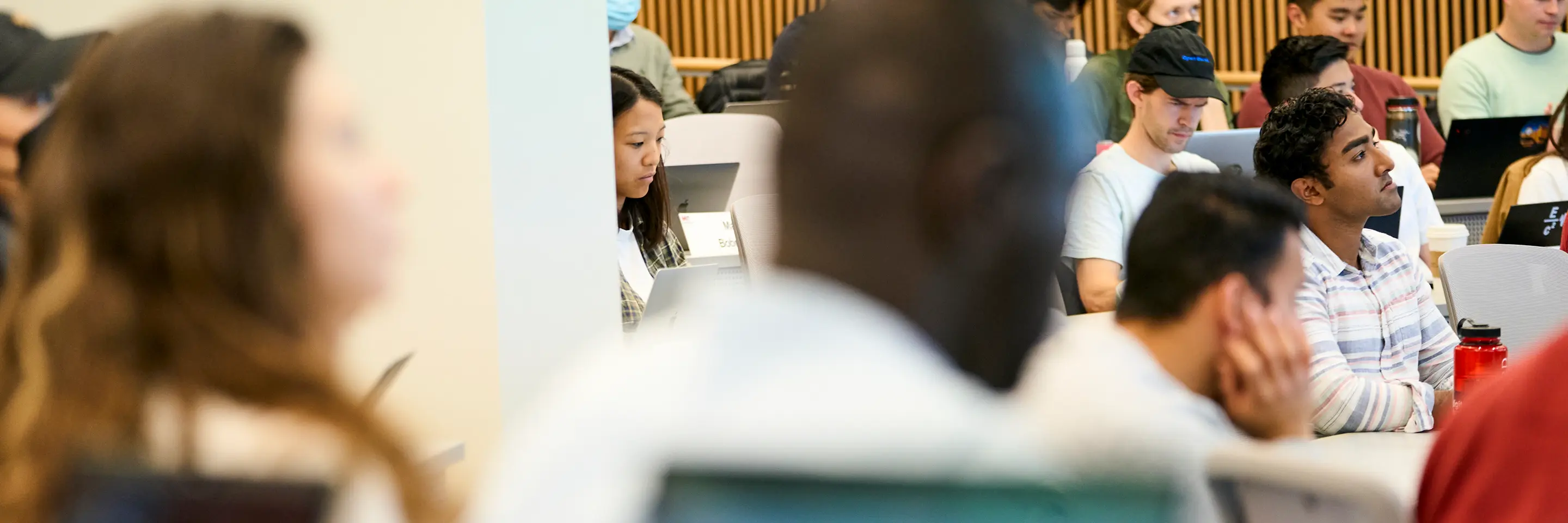 Students sitting in a classroom, listening to a lecture