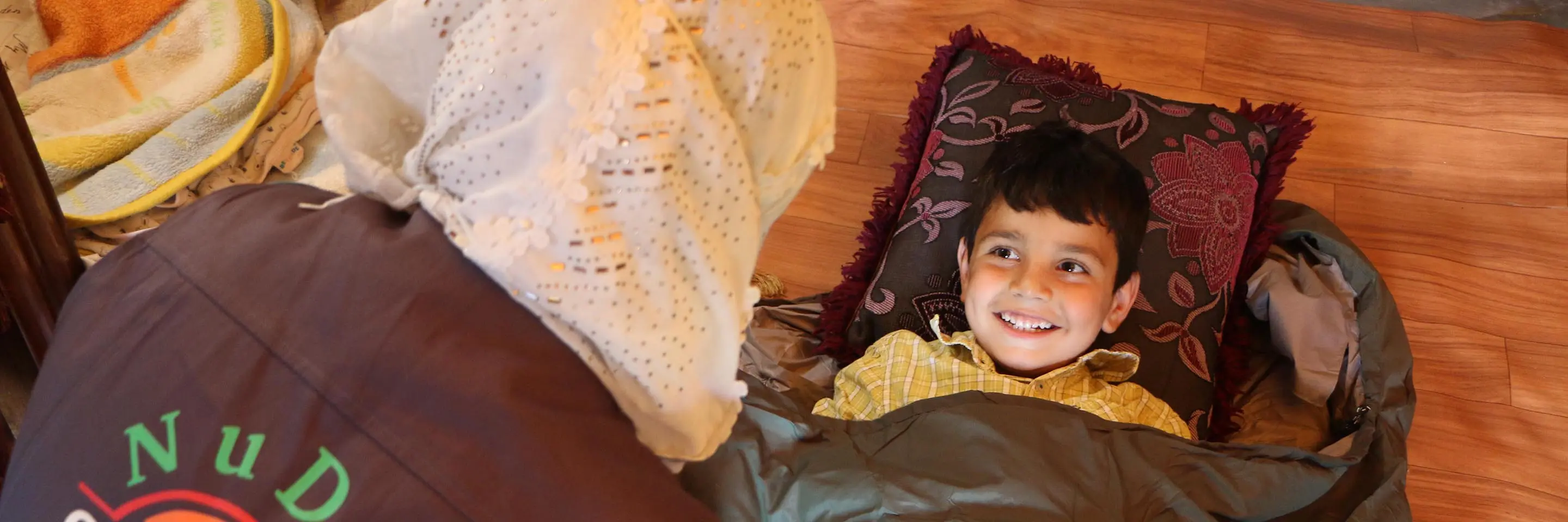 A young child gets comfortable in a TravlerPack sleeping bag.