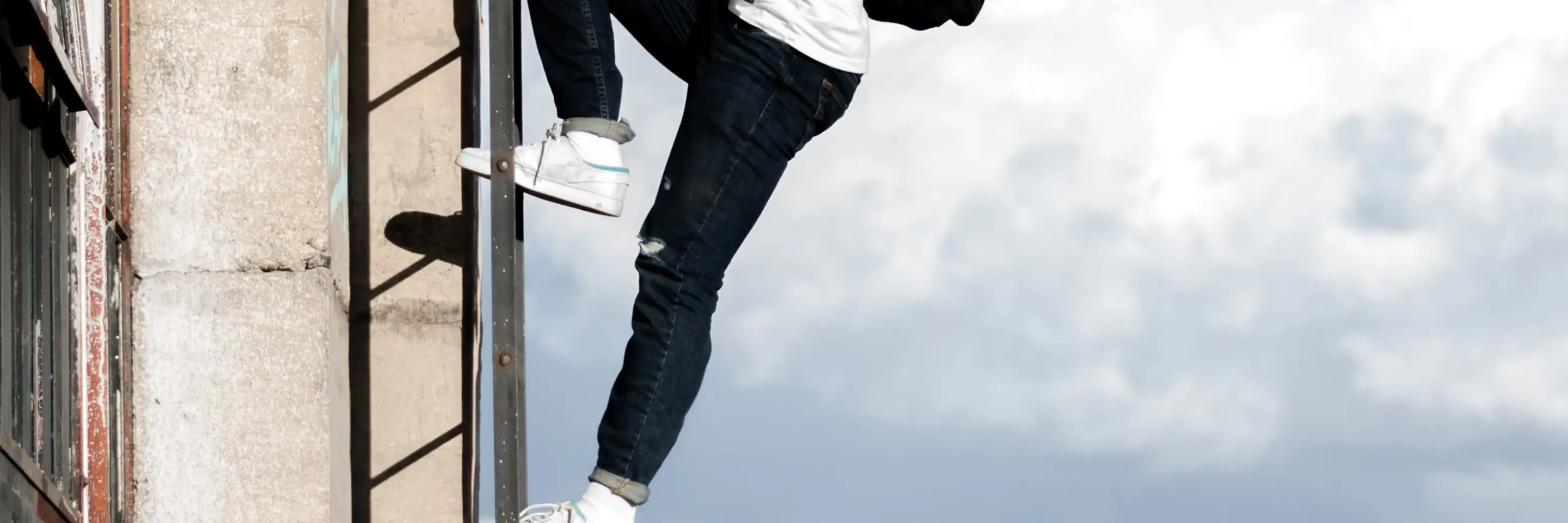 Image of a Man With Backpack Climbing a Ladder