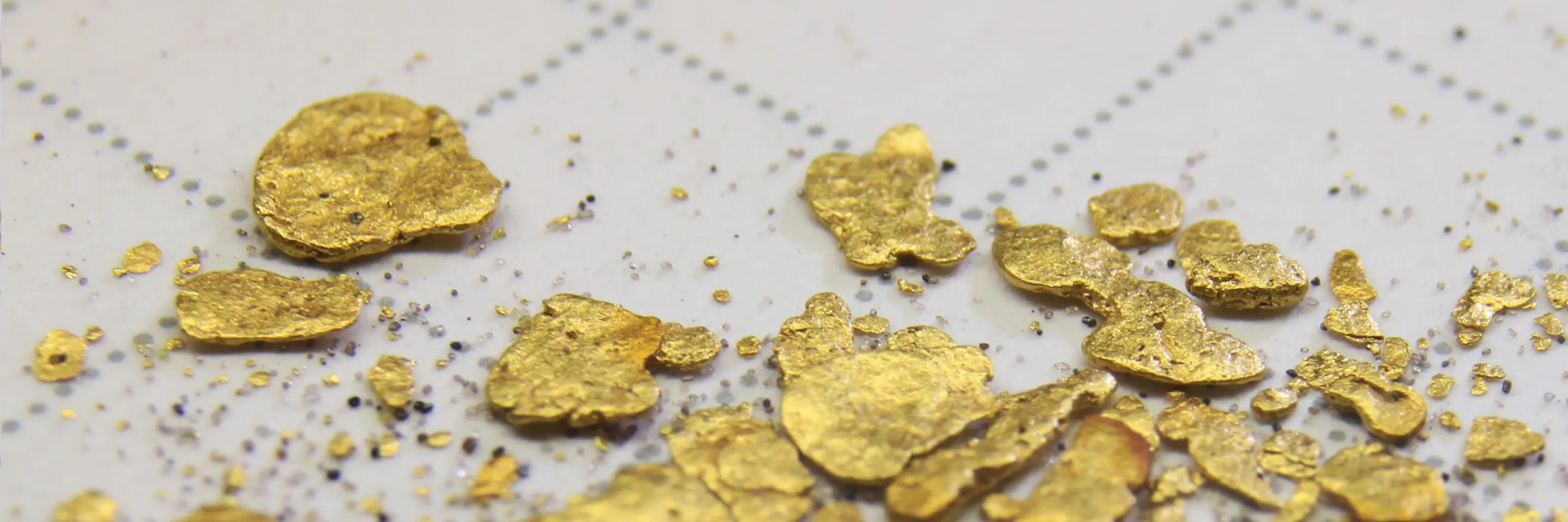 Gold flakes scattered across grid paper.