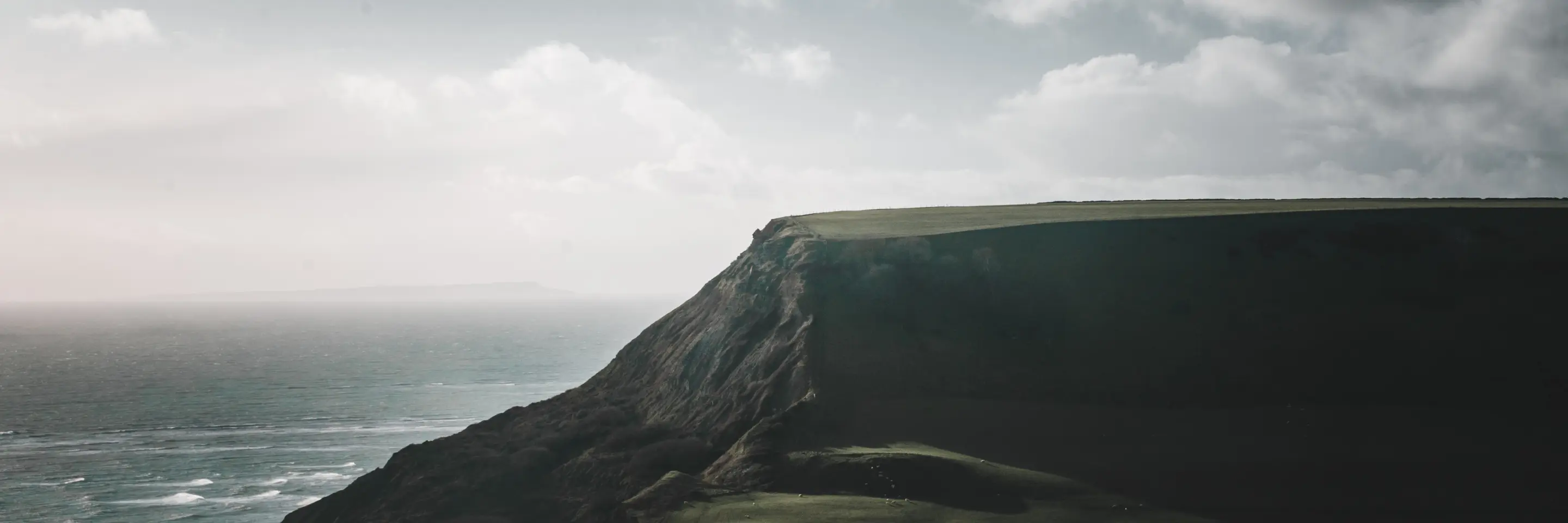  A plateau above a shoreline, with dark clouds above the plateau