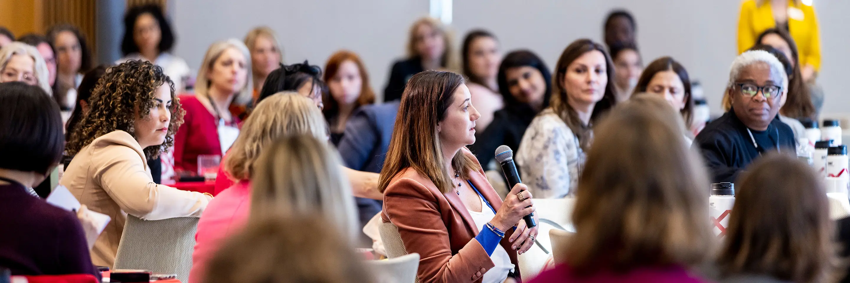 An MIT Sloan Women's Conference attendee asks a question during a session.