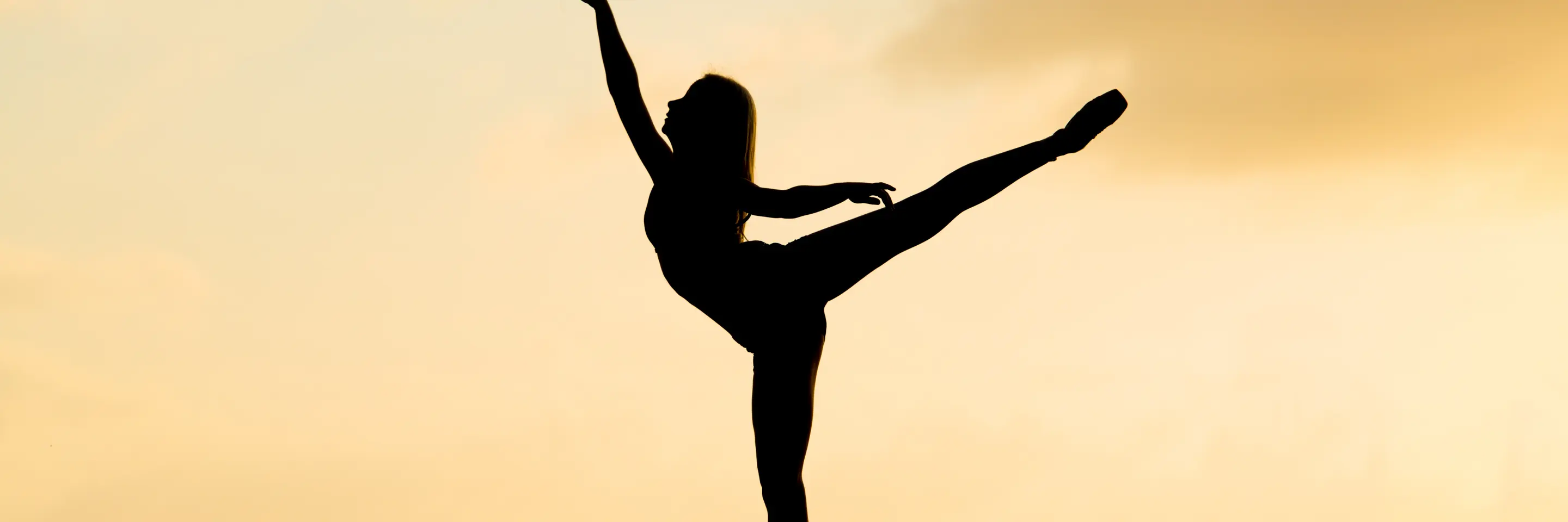 Silhouette of ballerina dancing in the sunset