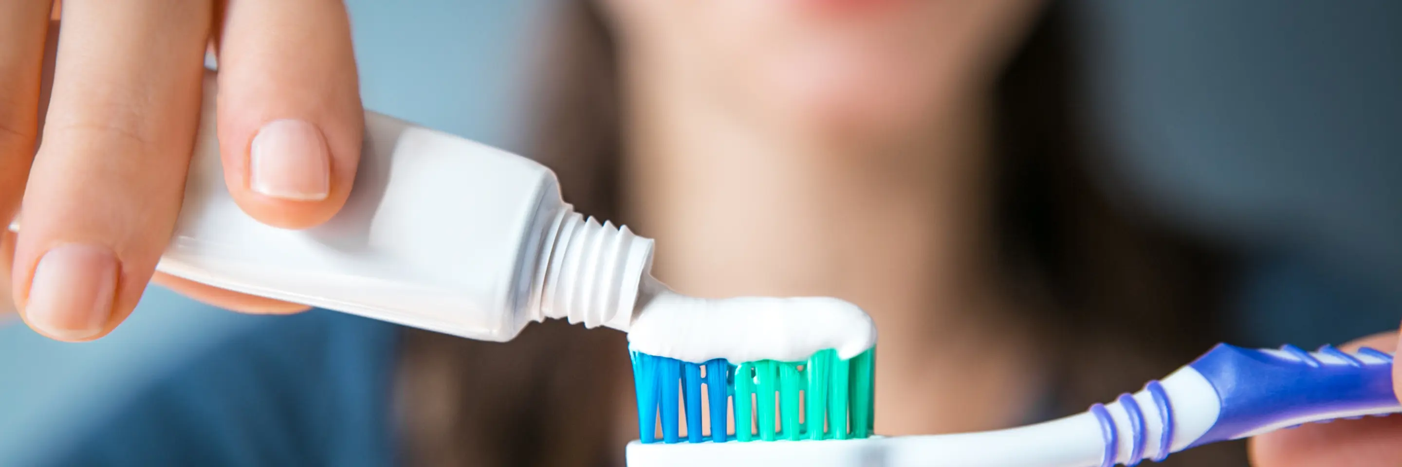 Woman squeezing toothpaste onto toothbrush